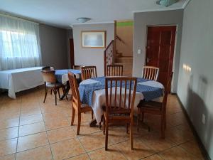 een eetkamer met 2 tafels en stoelen en een bed bij Gae la boroko @legodi's in Brakpan