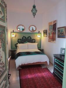 a bedroom with a large bed and a red rug at El Patio Courtyard House in Tunis