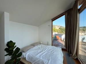 a bedroom with a bed and a large window at Casa Alegría in Trento