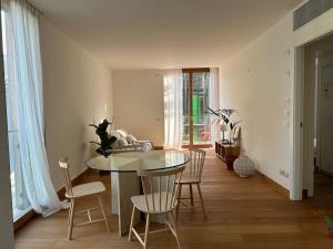 a dining room with a glass table and chairs at Casa Alegría in Trento