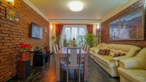 a living room with a table and a brick wall at Pension Bavaria in Braşov