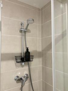 a shower with a shower head in a bathroom at Studio en centre ville + wifi in Labruguière