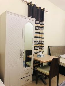 a cupboard with a desk and a table in a room at Private bedroom with Burj View in Dubai