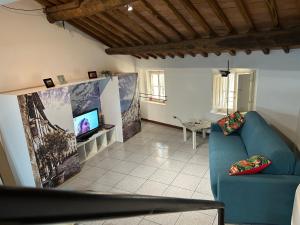 a living room with a blue couch and a tv at mansarda centro storico in Lucca