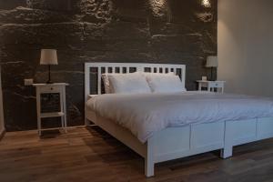 a bedroom with a white bed and two end tables at Saraya locanda in Al Salt