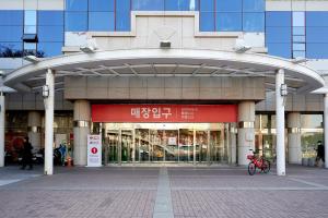 een ingang van een gebouw met een rood bord erop bij Travel House in Seoul