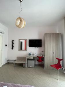 a living room with a desk and a red chair at Colibri B&B in Sciacca