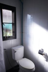 łazienka z białą toaletą i oknem w obiekcie isleep guesthouse w mieście Chiang Mai