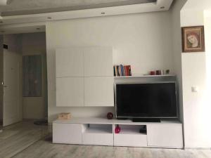 un gran centro de entretenimiento blanco con TV de pantalla plana en A cozy and modern apartment Krasno selo, en Sofía