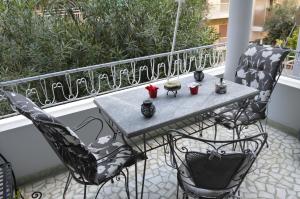 een tafel en stoelen op een balkon met planten bij Classy apt. Sokratous in Athene