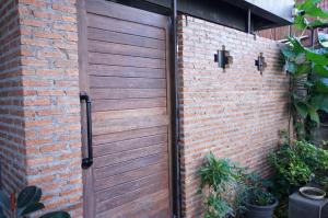 uma porta de garagem de madeira numa parede de tijolos em isleep guesthouse em Chiang Mai