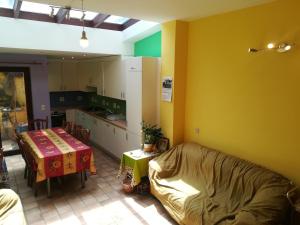una cucina con divano e tavolo in una camera di Prashanti a Nivelles