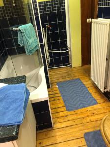 bagno con vasca e pavimento in legno di Prashanti a Nivelles