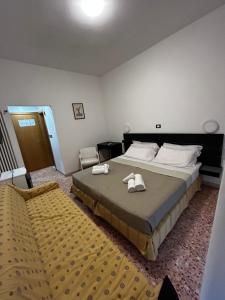 1 dormitorio con 1 cama grande y toallas. en Hotel Perla, en Cesenatico