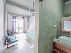 uma casa de banho e um quarto com um lavatório e uma cama em The Traveller Kandy em Kandy