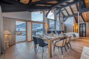 a dining room with a table and chairs and a bed at Les Chalets de La Clusaz - Appartement le Renne in La Clusaz