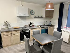a kitchen with a table and a dining room at L’escapade moulins in Moulins