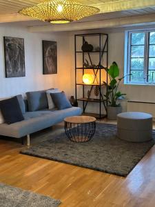 Troldegaarden Guesthouse في كوغ: غرفة معيشة مع أريكة زرقاء وطاولة
