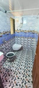 uma casa de banho com um WC e um piso de pedra em Hotel SolStay Inn Residency em Thane