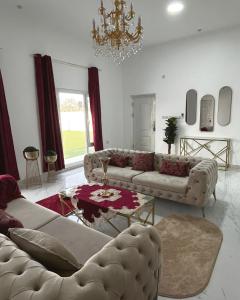 uma sala de estar com dois sofás e um lustre em Bareeq Rest House em Barka