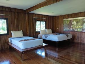 2 camas en una habitación con paredes de madera en Kohjum Freedom Resort, en Ko Jum