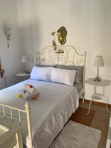 ein Schlafzimmer mit einem weißen Bett mit einer Statue an der Wand in der Unterkunft JayKay_PrivateRoom_FlicEnFlac in Flic-en-Flac