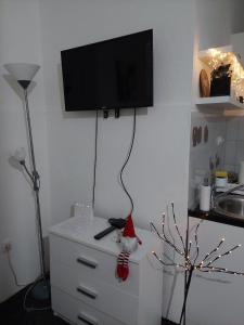 um quarto com um Pai Natal sentado numa cómoda com uma televisão em Cozy Max Studio em Jagodina
