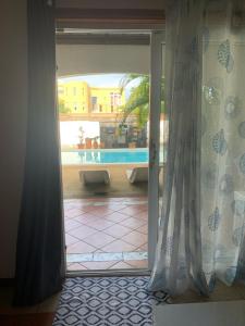 a sliding glass door with a view of a pool at JayKay_PrivateRoom_FlicEnFlac in Flic-en-Flac