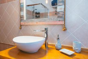 baño con lavabo blanco en una encimera de madera en Case Vacanze Il Sogno, en Porto Pino