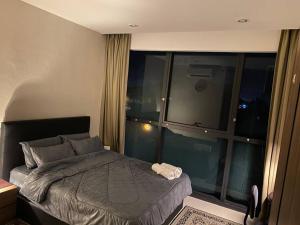 ein Schlafzimmer mit einem Bett und einem großen Fenster in der Unterkunft Malina Cozy Suite 3.0 @Kozi Square in Kuching