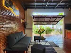 a living room with a couch and a brick wall at Mi Amor Vacation Home - A Private Big House with 2 separate Bedrooms, Central Location, Fully Furnished, Only 5 Minutes To The Beach in Phu Quoc