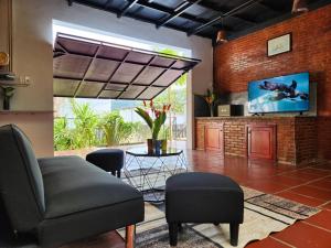 a living room with a couch and a tv at Mi Amor Vacation Home - A Private Big House with 2 separate Bedrooms, Central Location, Fully Furnished, Only 5 Minutes To The Beach in Phú Quốc