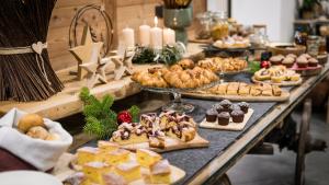 uma longa mesa cheia de diferentes tipos de pastelarias e sobremesas em ALPS LOVER em Campodenno