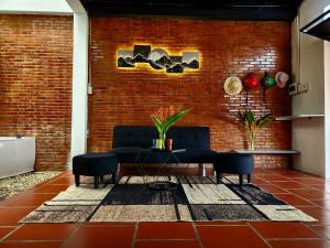 a living room with a couch and a brick wall at Mi Amor Vacation Home - A Private Big House with 2 separate Bedrooms, Central Location, Fully Furnished, Only 5 Minutes To The Beach in Phú Quốc
