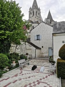 un patio con 2 sillas y un edificio con iglesia en Le Gite du Chevalier, en Loches