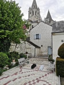 a courtyard with two chairs and a building with a church at Gite du Chevalier du fort st ours in Loches