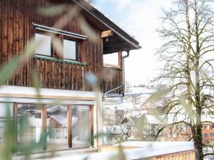 a house with windows on the side of it at Ninis - Ferienhaus im Bregenzerwald in Egg