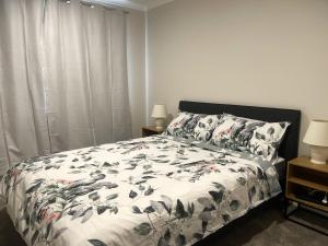 um quarto com uma cama com um edredão e almofadas em Murphys Guest Home em Auckland
