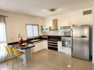 a kitchen with a stainless steel refrigerator and a table at arie apartment in Eilat