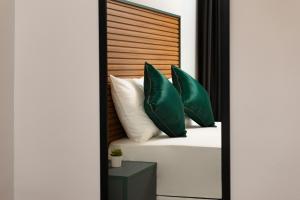 een slaapkamer met een bed met groene kussens bij G&B MANSION in Istanbul