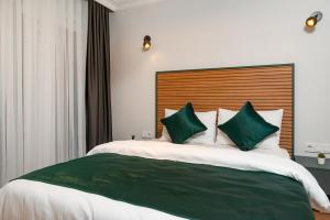 Un dormitorio con una cama grande con almohadas verdes y blancas en G&B MANSION, en Estambul
