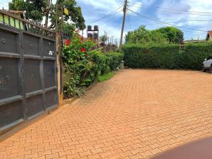 a brick driveway with a fence and a gate at House in Kampala in Kampala