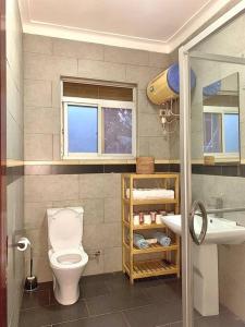uma casa de banho com um WC e um lavatório em House in Kampala em Kampala