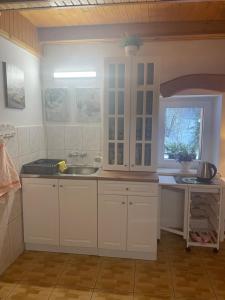 a kitchen with white cabinets and a sink at Ranczo Frodyma in Stronie Śląskie