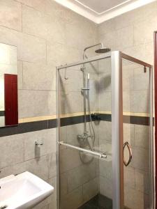 a bathroom with a shower and a sink at House in Kampala in Kampala