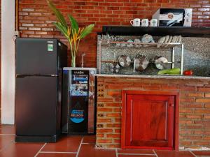 a refrigerator sitting next to a brick wall at Mi Amor Vacation Home - A Private Big House with 2 separate Bedrooms, Central Location, Fully Furnished, Only 5 Minutes To The Beach in Phu Quoc
