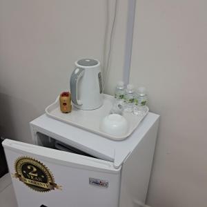 un piccolo frigorifero con lavandino e bottiglie d'acqua di Turtle Guest House a Sur