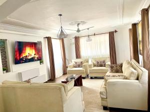 a living room with white furniture and a fireplace at Mudzini gardens - Luxury villa with a pool in Mombasa