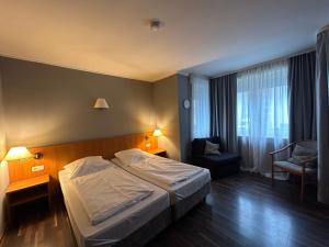 ein Hotelzimmer mit einem Bett und einem Stuhl in der Unterkunft WestEnd#106 in Frankfurt am Main