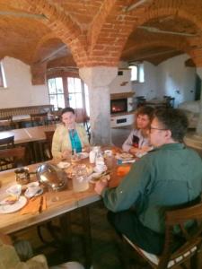 grupa ludzi siedzących przy stole jedzących w obiekcie Tubej turist farm - wooden hayloft w mieście Bohinjska Bistrica